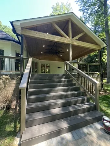 Covered porch with stained wood ceiling and composite steps