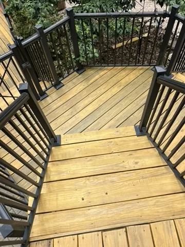 Stained wood deck stairs with black aluminum railing