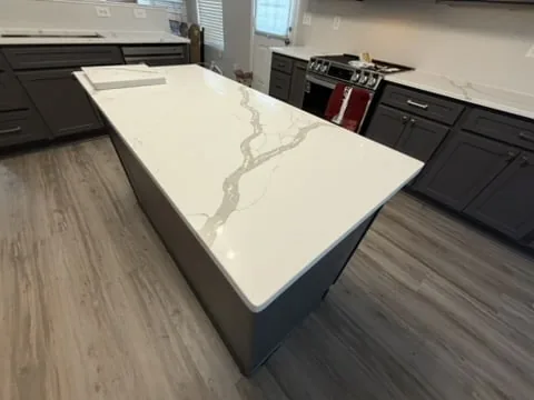 Kitchen island with marble-look quartz countertop and gray cabinets