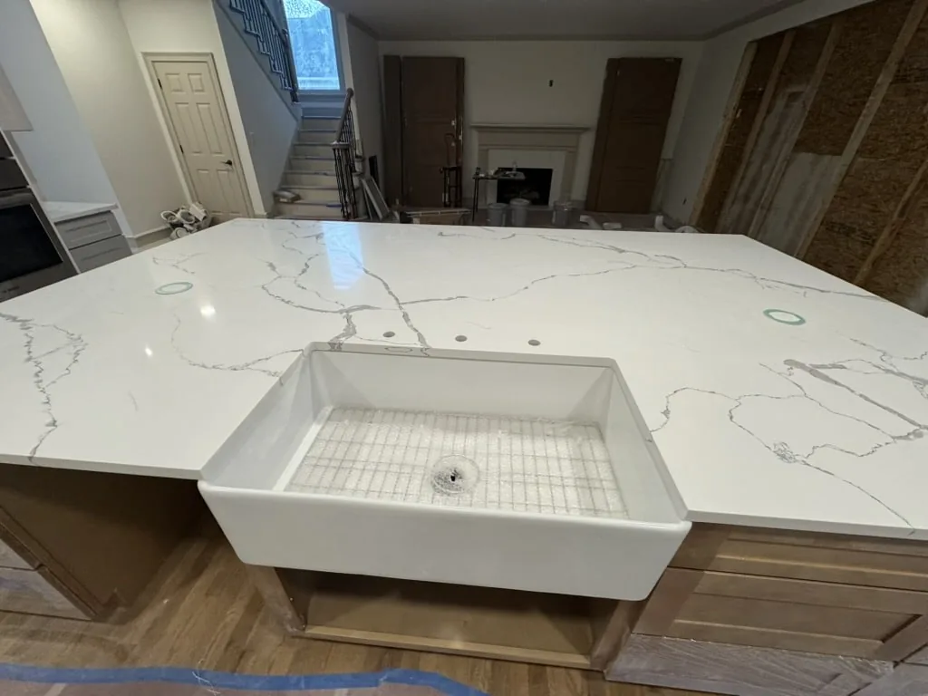 Quartz with a farmhouse sink — no sealing, ever.